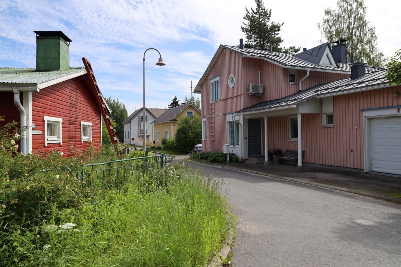 Risteyksen tien eri puolilla on punainen ja vaaleanpunainen vanha talo.